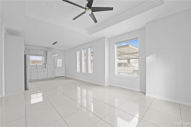 tiled spare room with sink, a tray ceiling, plenty of natural light, and ceiling fan