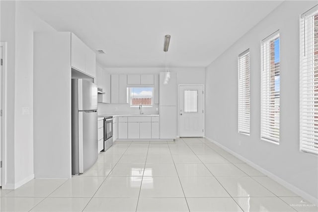 kitchen featuring sink, appliances with stainless steel finishes, white cabinetry, extractor fan, and light tile patterned flooring