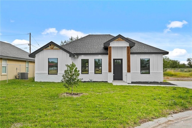 view of front of house featuring central air condition unit and a front lawn