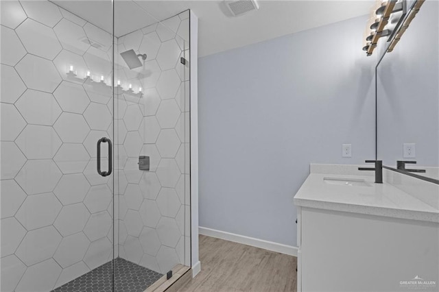 bathroom featuring vanity, an enclosed shower, and hardwood / wood-style floors