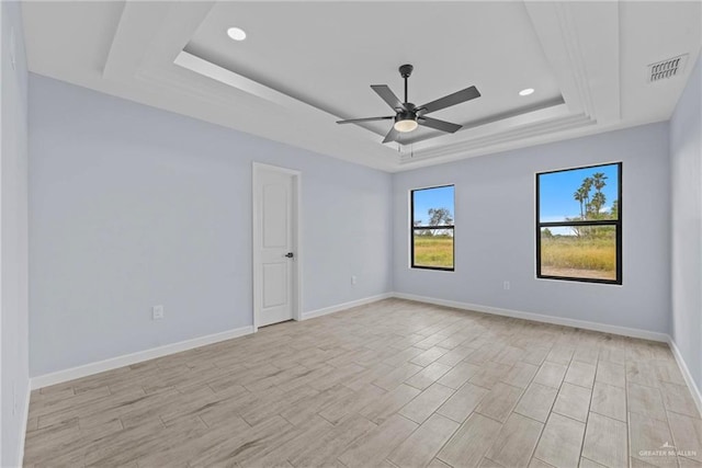 empty room with a tray ceiling and ceiling fan