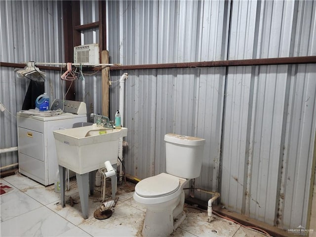 bathroom with washer / clothes dryer and toilet