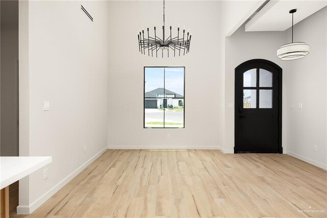 2717 E Versace Dr, Edinburg, TX 78542 - entrance foyer with light wood-type flooring, baseboards, arched walkways, and a chandelier