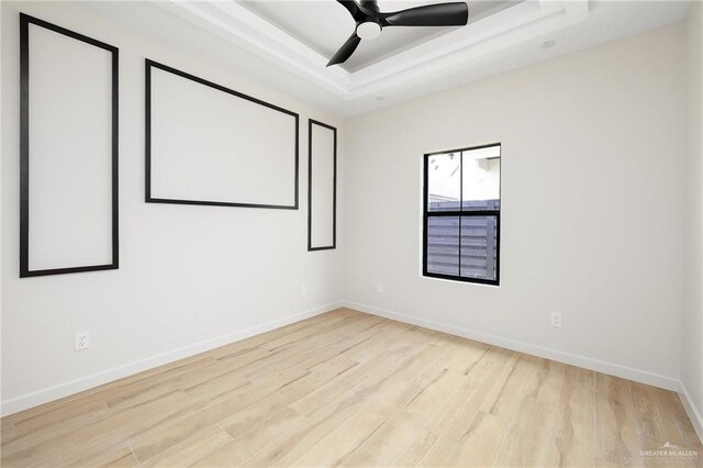 2717 E Versace Dr, Edinburg, TX 78542 - spare room featuring light wood-style floors, baseboards, a tray ceiling, and a ceiling fan