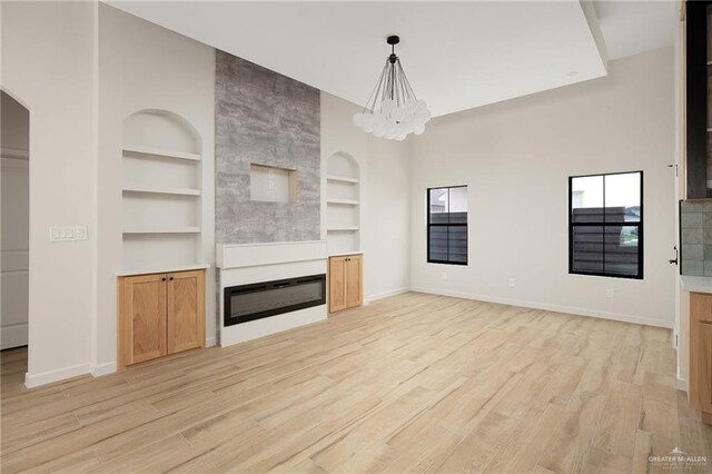2717 E Versace Dr, Edinburg, TX 78542 - unfurnished living room with built in features, baseboards, and light wood-style flooring