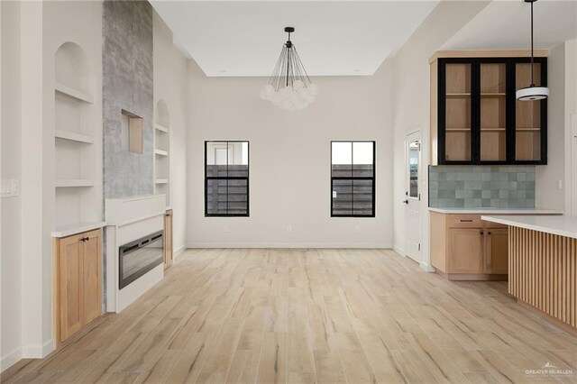 2717 E Versace Dr, Edinburg, TX 78542 - kitchen featuring open shelves, built in features, a chandelier, light countertops, and plenty of natural light