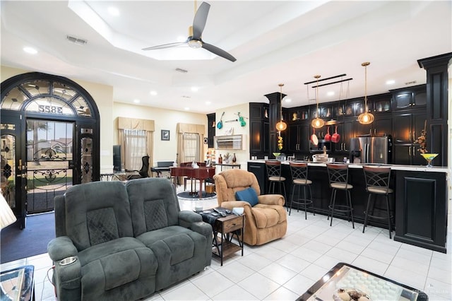 living room with recessed lighting, a raised ceiling, visible vents, light tile patterned flooring, and ceiling fan