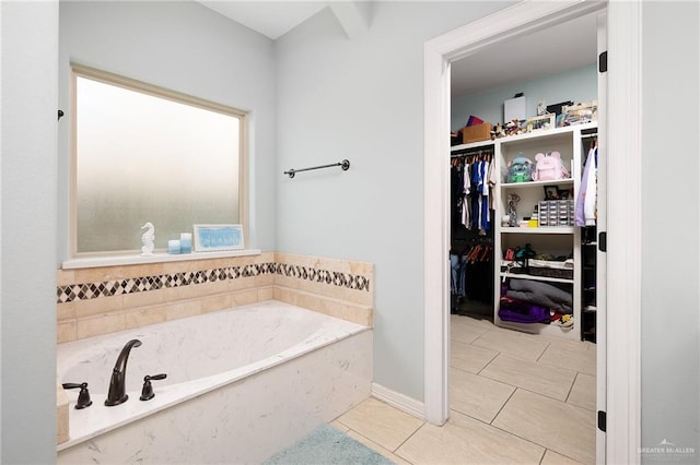 13410 N 36th Ln, Edinburg, TX 78541 - bathroom featuring a garden tub, tile patterned flooring, and a walk in closet