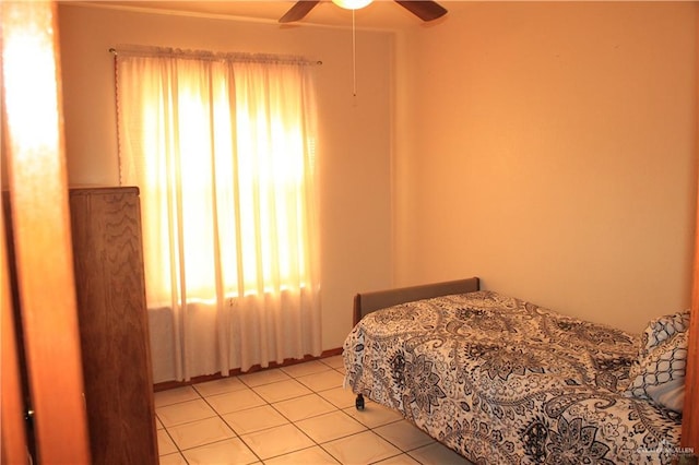 bedroom with ceiling fan and light tile patterned flooring