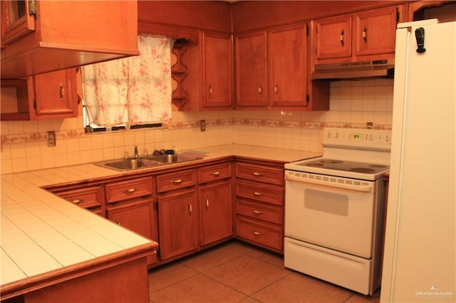 kitchen with backsplash, electric stove, sink, light tile patterned floors, and tile counters