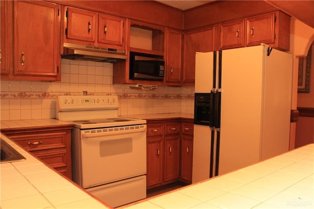 kitchen with white appliances, tasteful backsplash, and tile counters