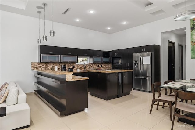 kitchen with kitchen peninsula, hanging light fixtures, tasteful backsplash, stainless steel fridge with ice dispenser, and black microwave