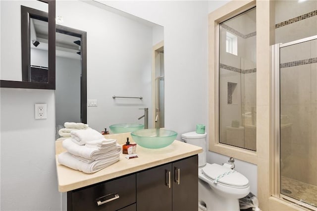 bathroom featuring vanity, toilet, and a shower with shower door