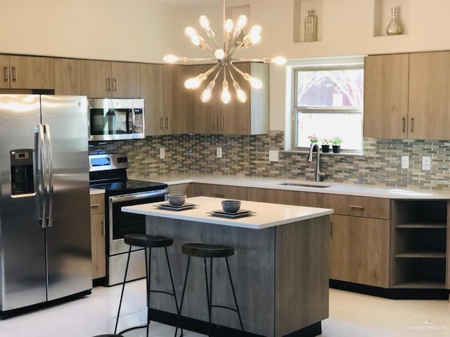 kitchen featuring appliances with stainless steel finishes, light countertops, a sink, and a kitchen island