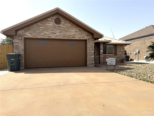 ranch-style home featuring brick siding, an attached garage, central air condition unit, metal roof, and driveway