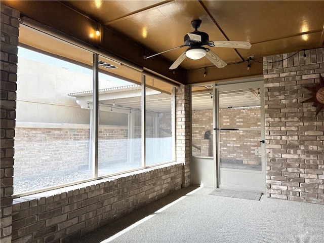 unfurnished sunroom with ceiling fan