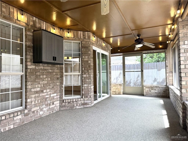 unfurnished sunroom featuring ceiling fan