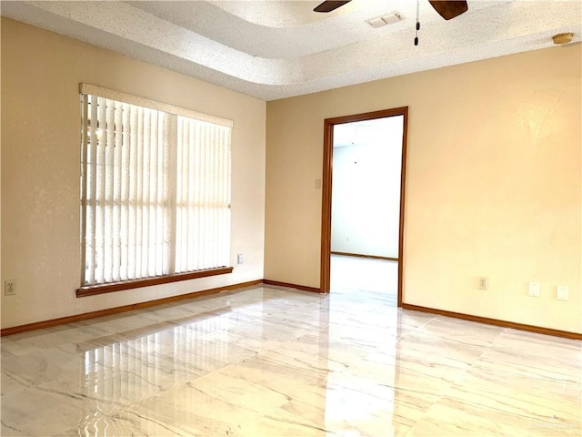 spare room featuring visible vents, baseboards, a textured ceiling, and marble finish floor