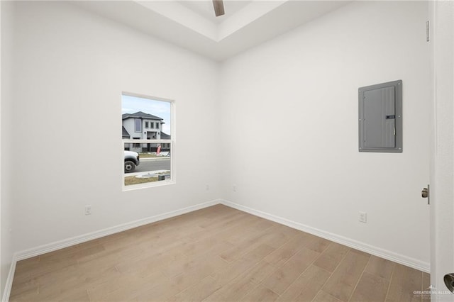 spare room with electric panel, light hardwood / wood-style floors, and ceiling fan