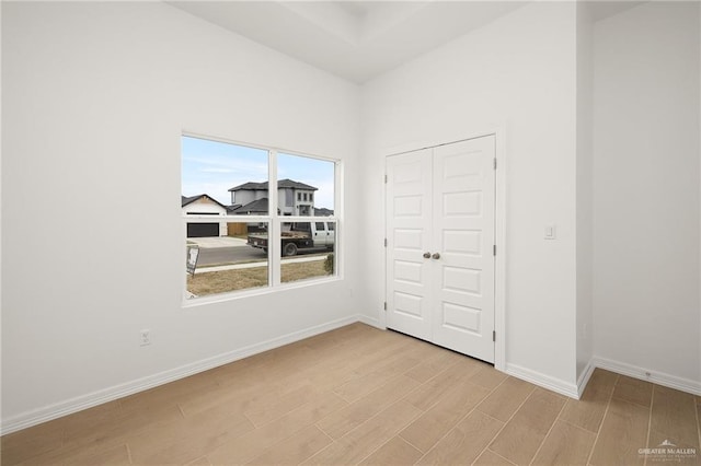 unfurnished bedroom with light wood-type flooring and a closet