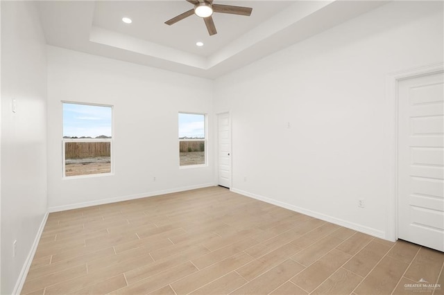 spare room featuring a high ceiling, ceiling fan, and a tray ceiling