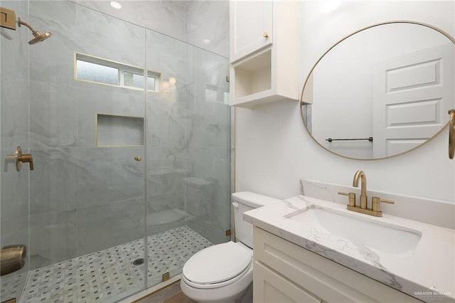 bathroom featuring vanity, a shower with shower door, and toilet