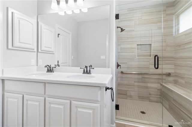 bathroom featuring a shower with shower door and vanity