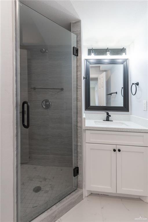 bathroom with vanity and a shower with shower door