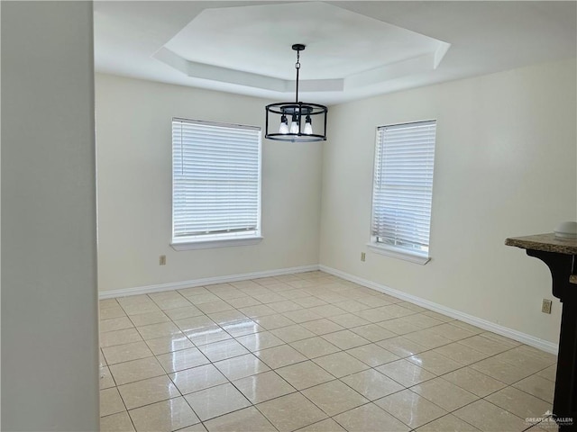 unfurnished dining area featuring a notable chandelier, a raised ceiling, and light tile patterned floors