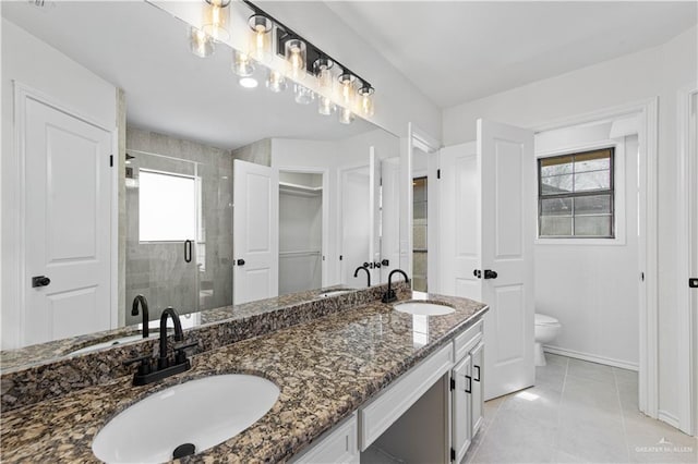 bathroom featuring a shower with door, vanity, tile patterned floors, and toilet