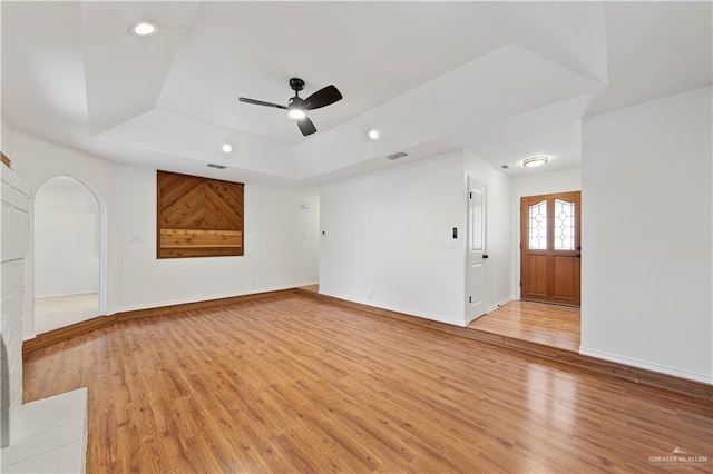 unfurnished room featuring ceiling fan, a raised ceiling, and hardwood / wood-style floors