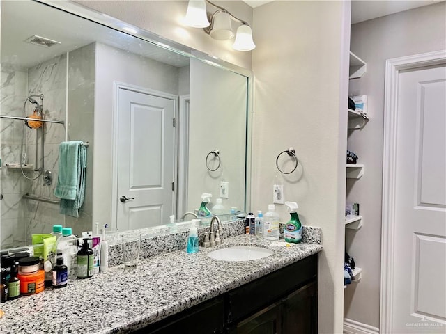 bathroom with vanity and tiled shower