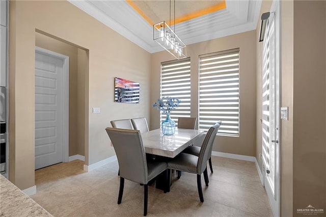 dining room with ornamental molding and a raised ceiling