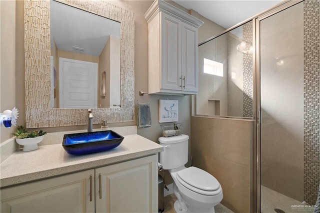 bathroom featuring vanity, a shower with door, and toilet