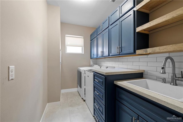 laundry room with sink, light tile patterned floors, washer and clothes dryer, and cabinets