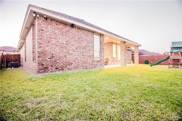 view of side of home featuring a playground, central air condition unit, and a lawn