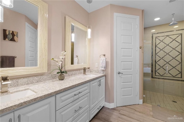 bathroom featuring hardwood / wood-style flooring, vanity, and walk in shower