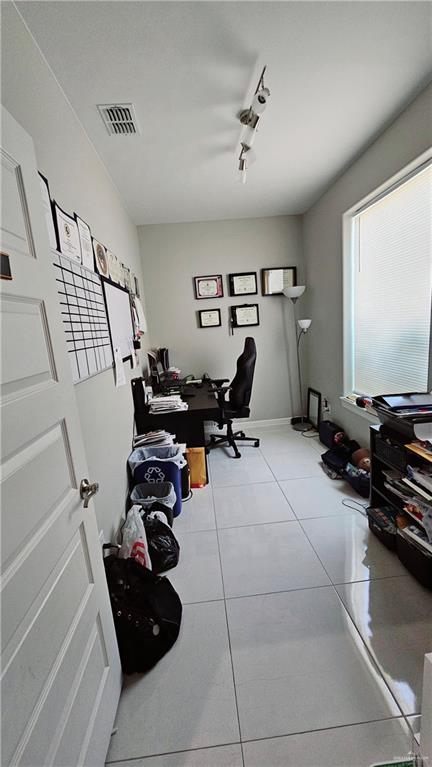 office space with light tile patterned flooring and track lighting