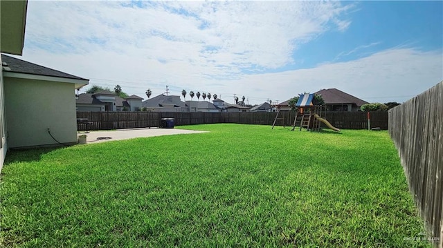 view of yard featuring a playground and a patio