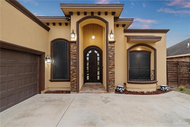 exterior entry at dusk featuring a garage