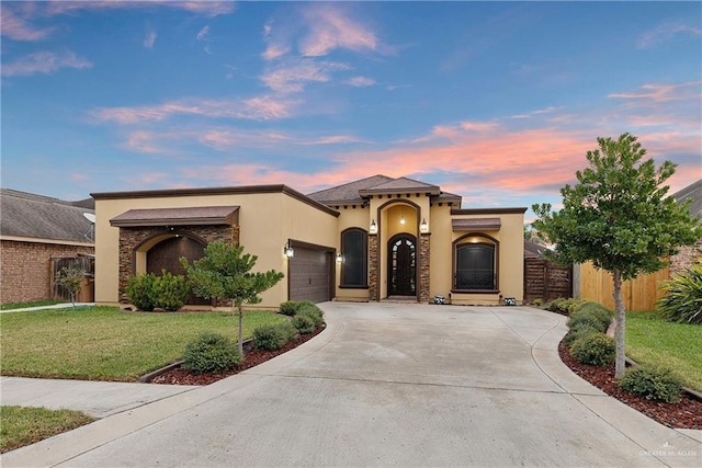 mediterranean / spanish-style house with a garage and a lawn