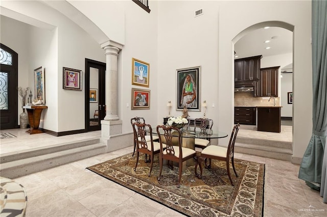 1807 Pecos St, Mission, TX 78572 - dining area featuring a high ceiling, decorative columns, arched walkways, and baseboards