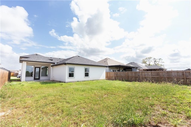 rear view of property with a yard