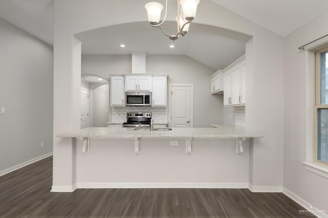 14222 Chalk Ridge Dr, Mcallen, TX 78504 - kitchen featuring appliances with stainless steel finishes, tasteful backsplash, white cabinets, arched walkways, and light stone countertops