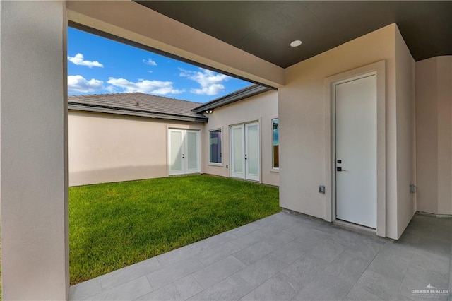 exterior space with french doors and a lawn