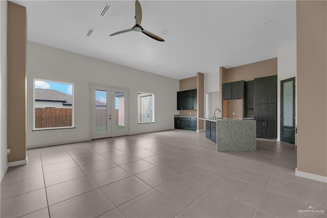 unfurnished living room featuring ceiling fan, sink, and light tile patterned flooring