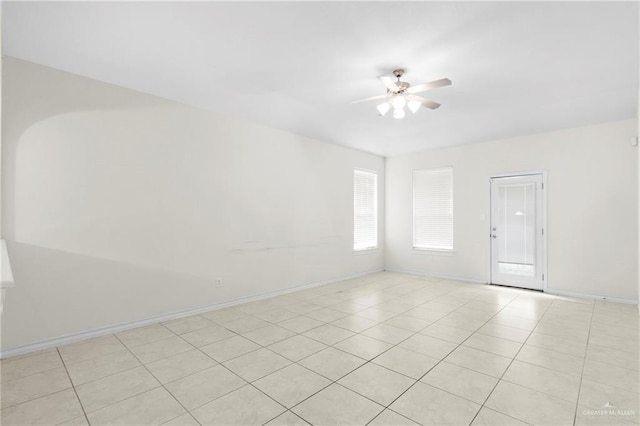 empty room featuring light tile patterned flooring and ceiling fan