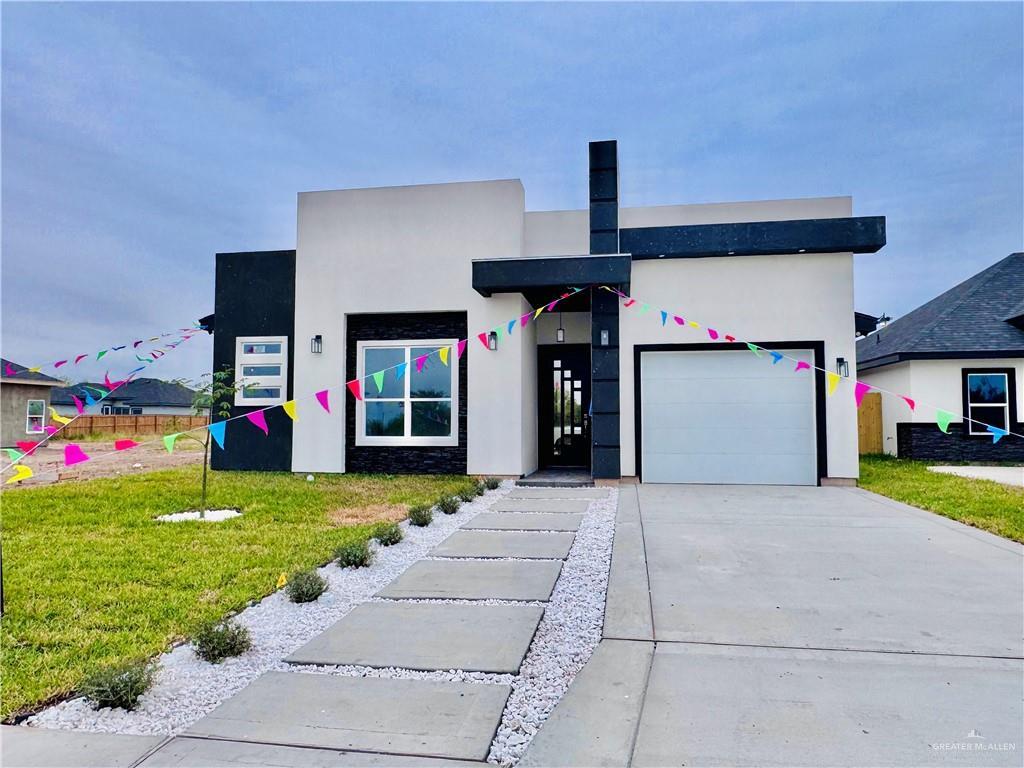 contemporary home featuring a front lawn and a garage