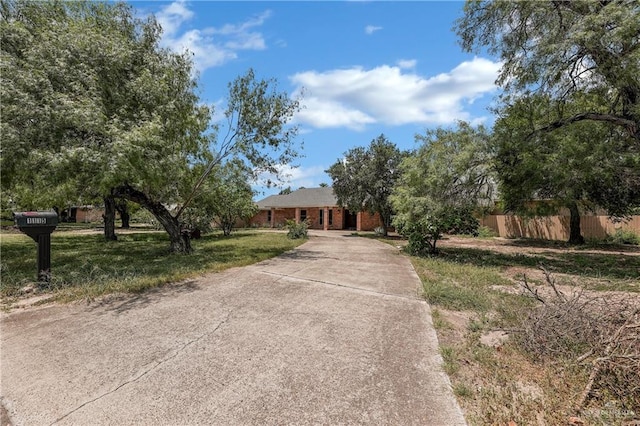 view of front of home featuring driveway and fence