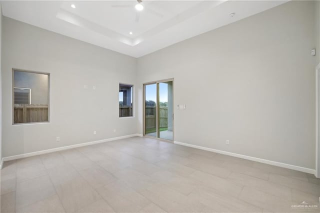 unfurnished room featuring baseboards, a raised ceiling, a ceiling fan, and recessed lighting